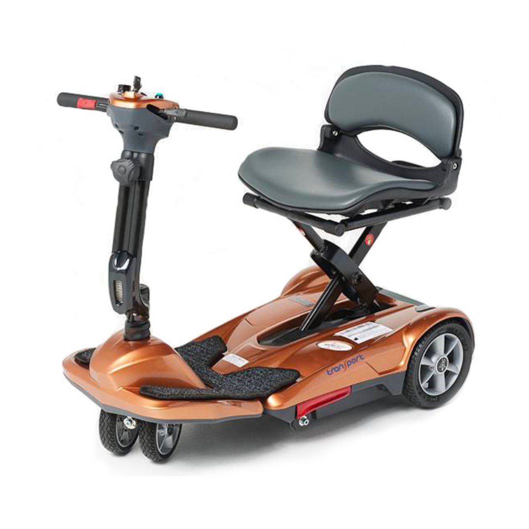 The EV Rider TranSport M Easy Move S19M is a compact, orange folding travel scooter featuring three small front wheels and two larger rear wheels, with a padded seat, backrest, handlebars, and foldable frame for easy transport and accessibility.